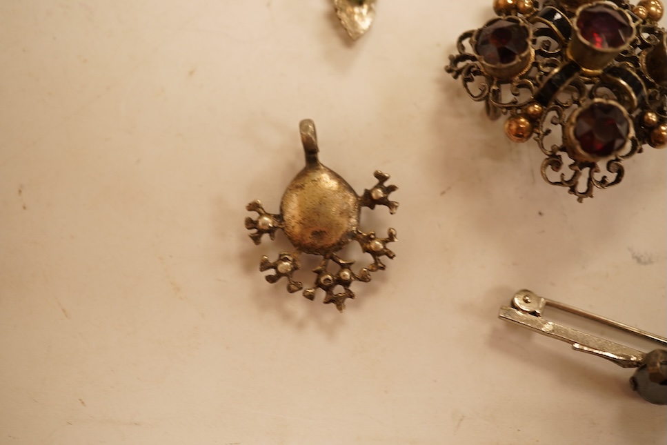 A late 19th/early 20th century Viennese pierced white metal, enamel and garnet cluster set brooch, 34mm, together with four other items of paste set jewellery.